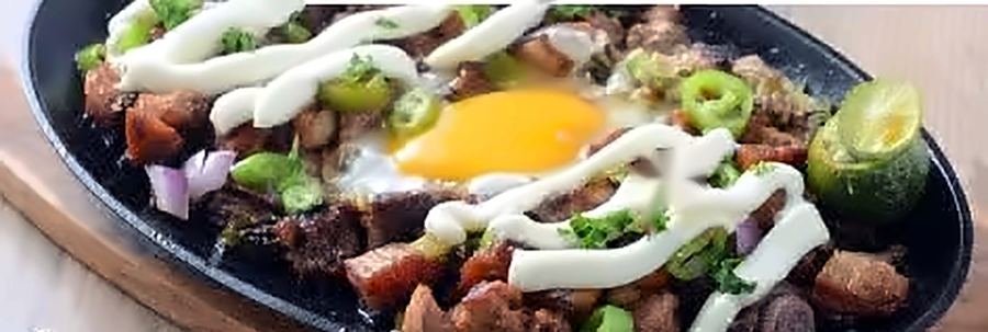 Sizzling sisig platter with egg and calamansi